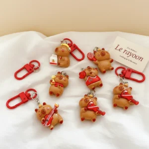 Top-down view of a 6-piece set of glossy resin capybara bag charms featuring red sports and music accessories like guitars, tennis rackets, and headphones.