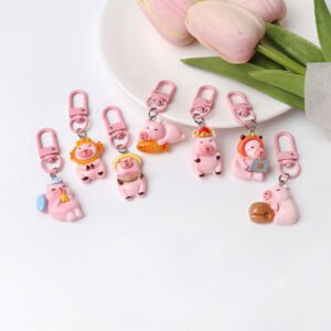 Collection of 7 pink resin capybara keychains featuring laptop, watermelon, and sleeping designs.