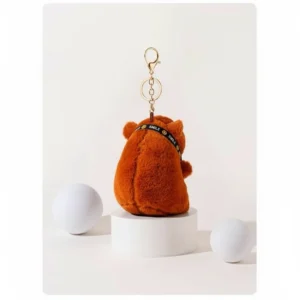 Side profile of the photographer capybara plush showing the thickness of the body and the camera strap detail.