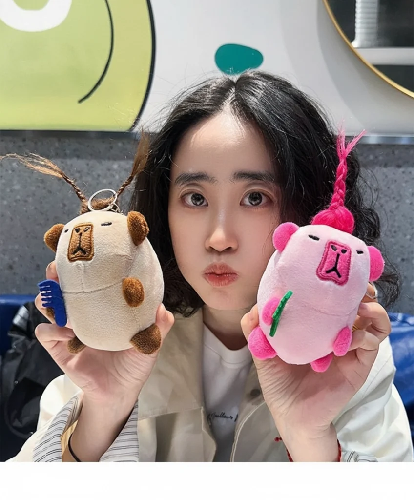 A girl holding both color variations of the wild hair capybara keychains, showing their funny expressions.