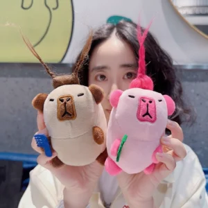 A girl holding both color variations of the wild hair capybara keychains, showing their funny expressions.