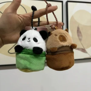 A cylindrical plush capybara purse and a panda purse standing upright, featuring silicone loop straps and zippered compartments, displayed on a desk.