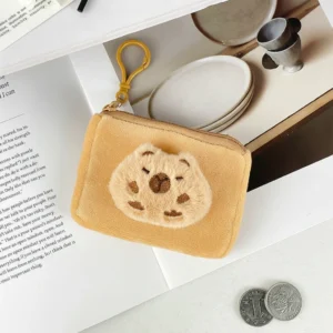 A soft, yellow rectangular capybara purse with a zipper and keychain clip